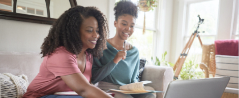 Mother and daughter taking notes at home