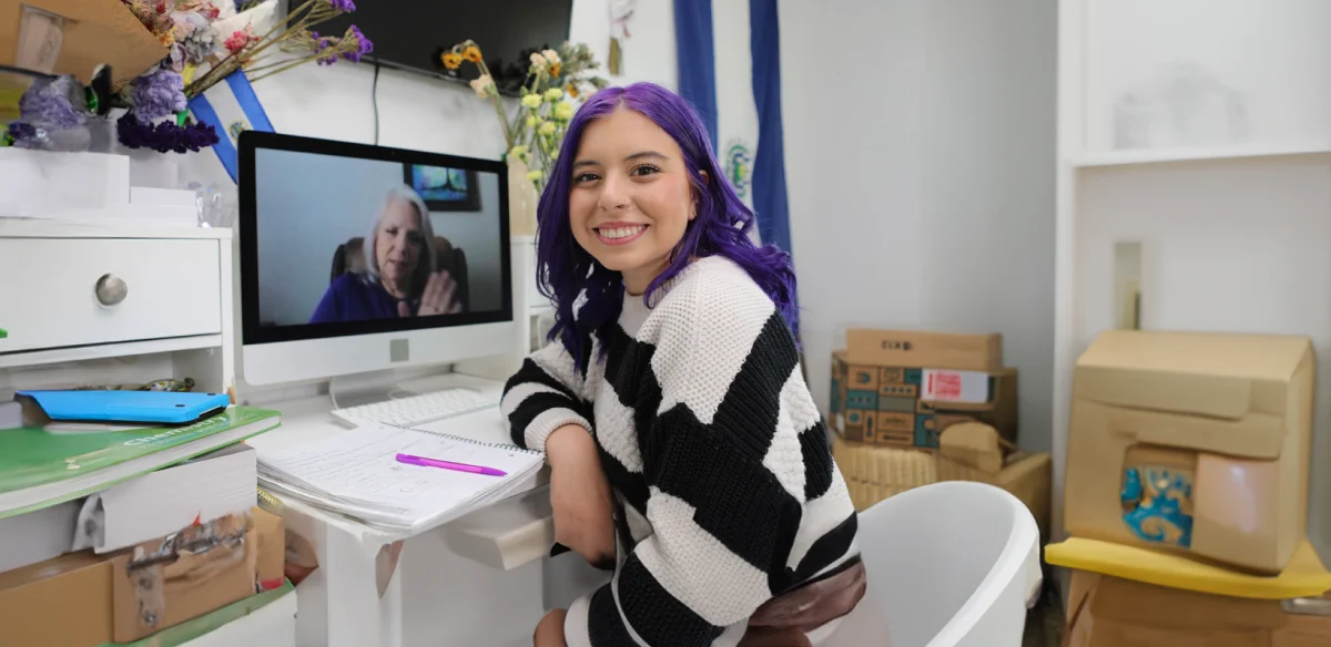 High school student attending to an online class wearing a stripped sweater